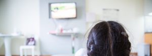 young girl watching hospital tv