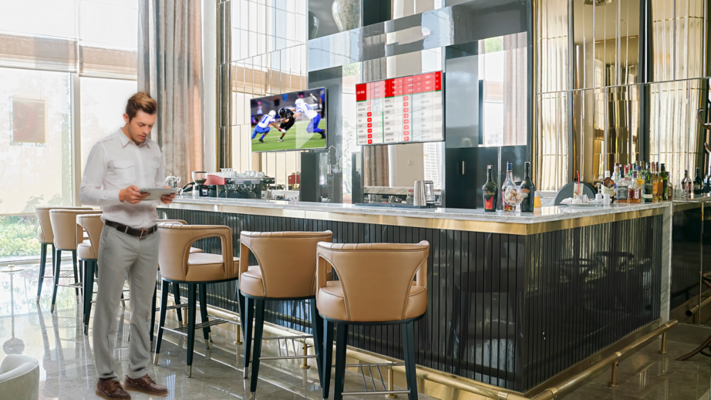 LG hotel technology solutions seamlessly integrated into a stylish hotel bar setting. The advanced technology includes modern displays, interactive features, and sophisticated audio systems, enhancing the ambiance and providing a cutting-edge guest experience.