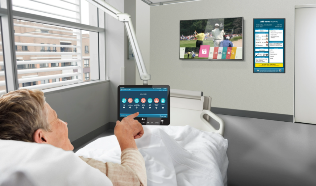 Image showcasing a patient using an LG hospital-grade smart TV in the context of Technology-Enabled Personalized and Preventative Medicine. The visual illustrates the patient-centric approach, as the individual engages with the smart TV to access personalized health information and proactive healthcare content. This technology empowers patients, promoting self-care and contributing to a more engaged and informed healthcare experience.