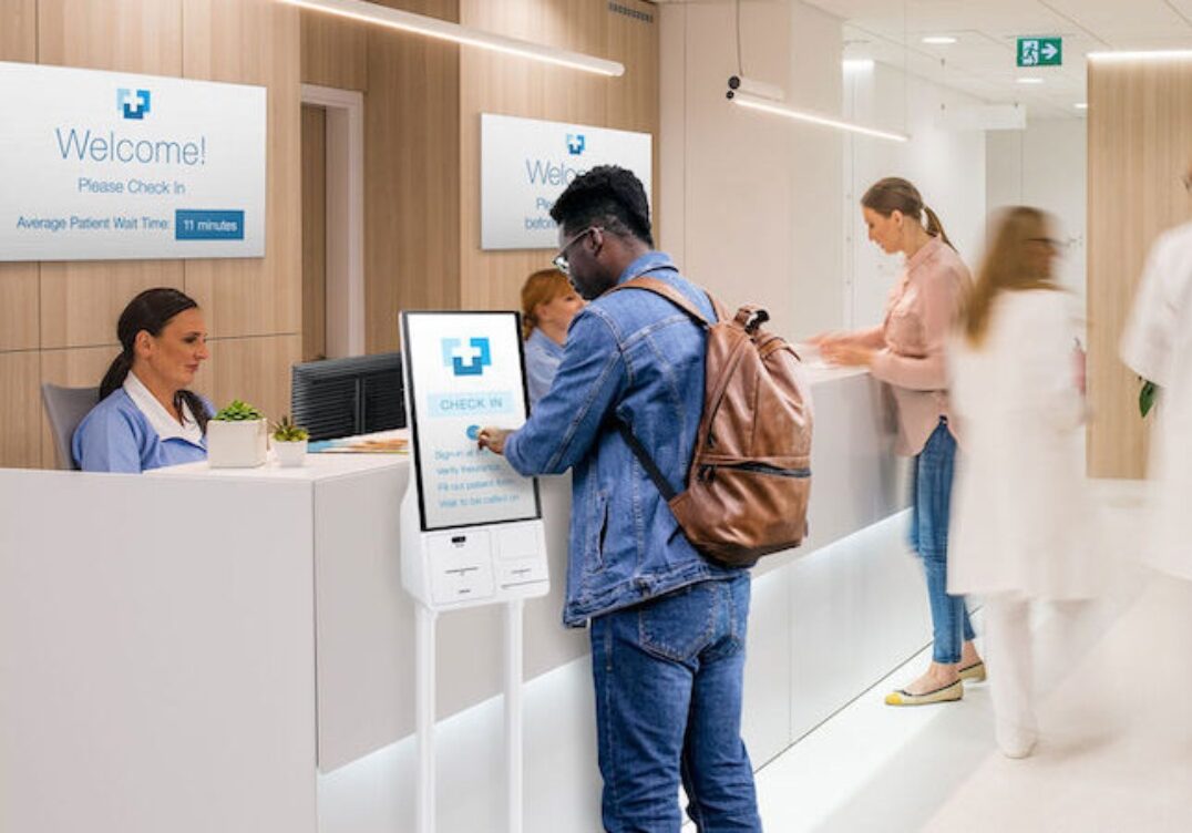 Peerless AV healthcare tv systems Peerless digital signage kiosk displaying welcome message in hospital lobby