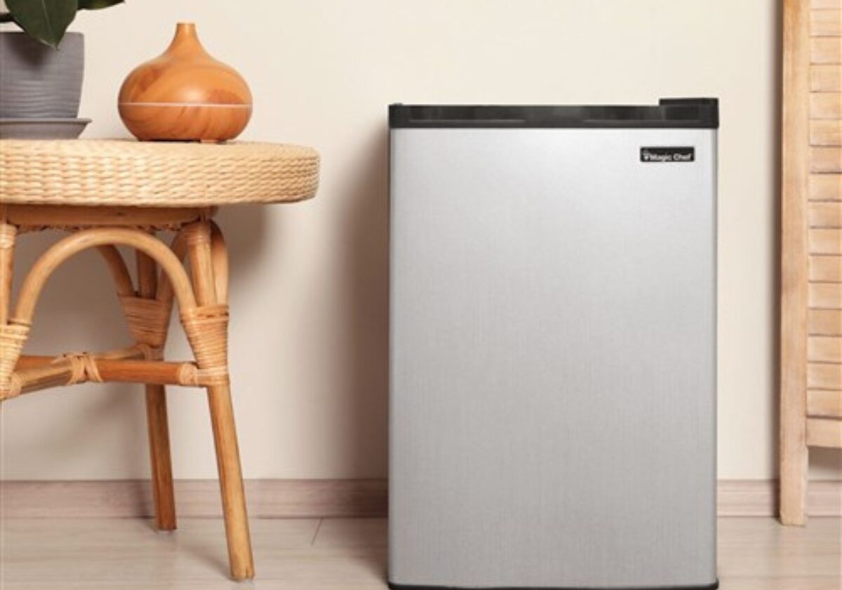 hotel mini fridge Magic Chef mini fridge placed near a desk in a hotel room. Hospitality-focused compact refrigerator for guest convenience and in-room refreshments.