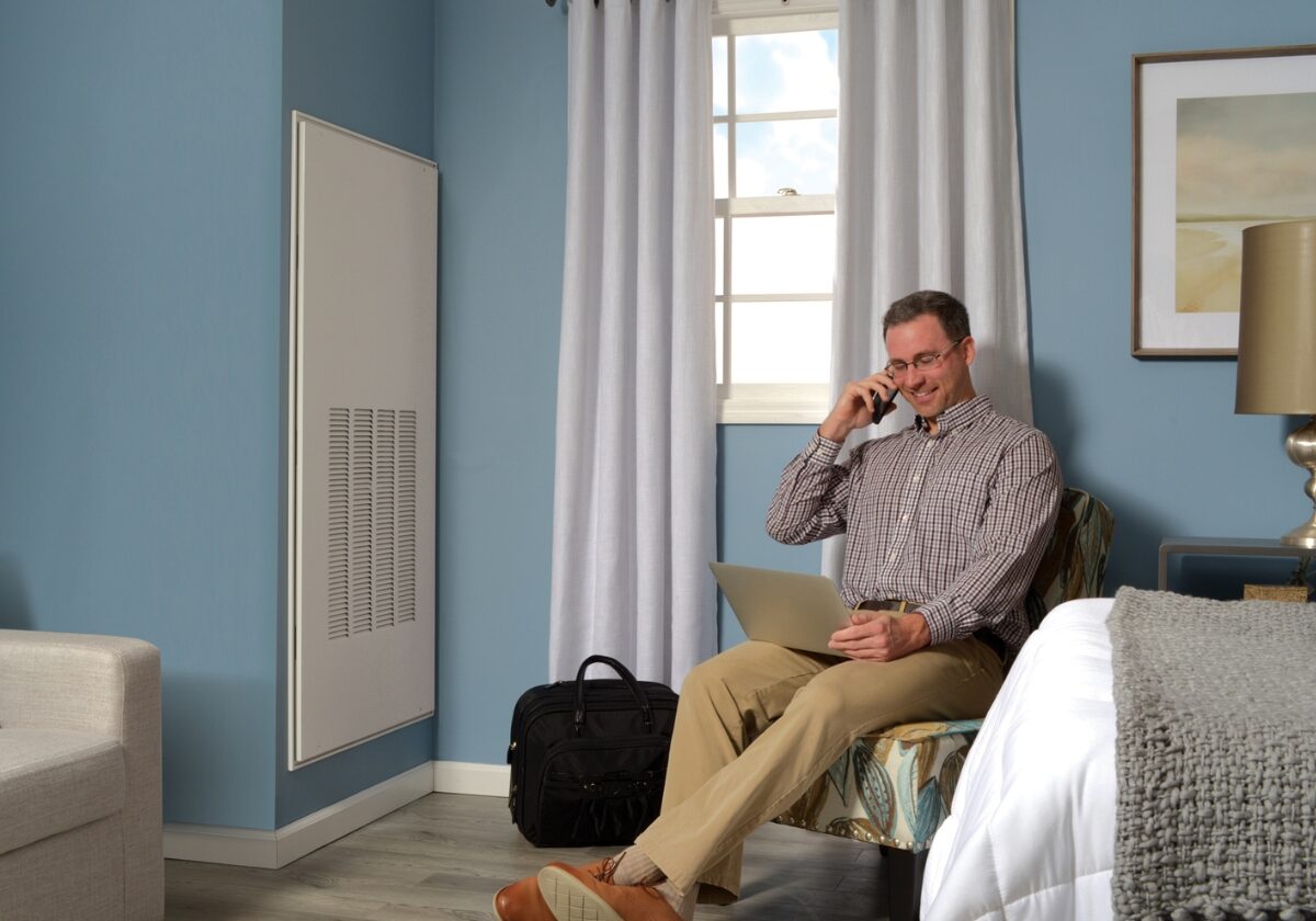 Modern hotel suite with a GE Zoneline® Ultimate V vertical PTAC concealed within a corner enclosure.